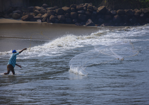 Fishermen Throwing His Nets To The Sea On The Beach, Kochi, India