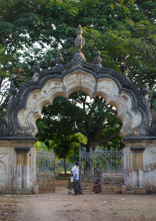 A Man With A Bike And A Bucket Of Milk Chatting With A Woman At The Gateway Of A Park In Mysore, India