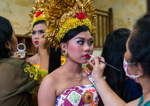 A Woman Applying Makeup To A Teenager Girl In Traditional  Costume Before A Tooth Filing Ceremony