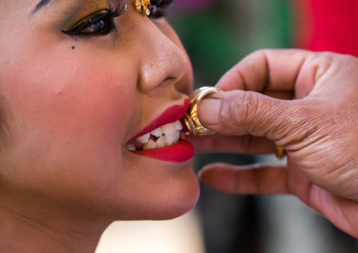 A Teenager Girl Having Her Teeth Blessed With A Ring By A Priest Before A Tooth Filing Ceremony