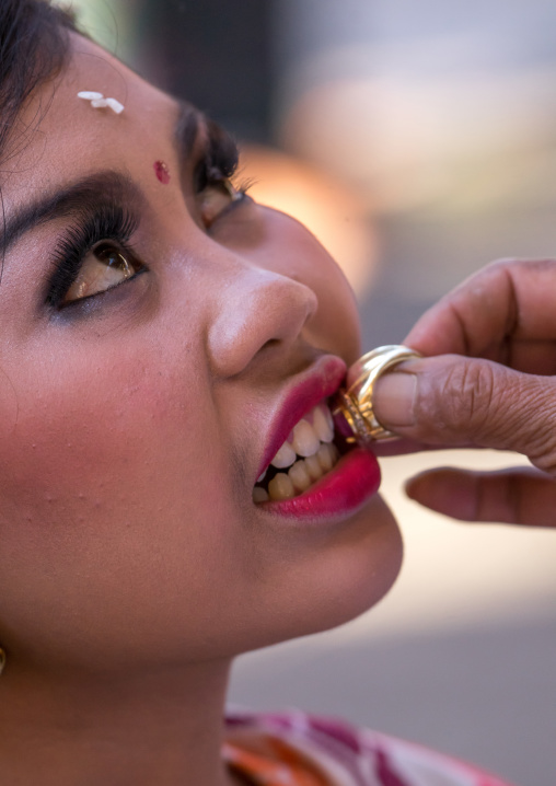 A Teenager Girl Having Her Teeth Blessed With A Ring By A Priest Before A Tooth Filing Ceremony