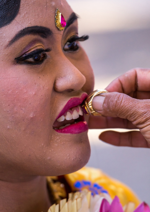 A Teenager Girl Having Her Teeth Blessed With A Ring By A Priest Before A Tooth Filing Ceremony