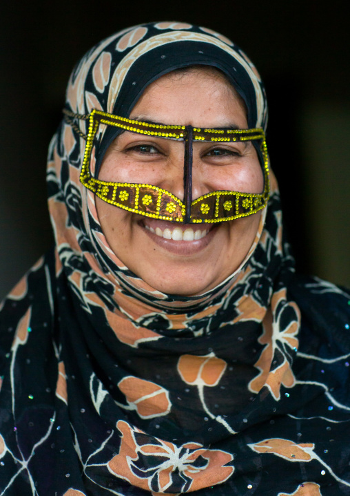 a smiling bandari woman wearing a traditional mask called the burqa with a moustache shape, Qeshm Island, Salakh, Iran