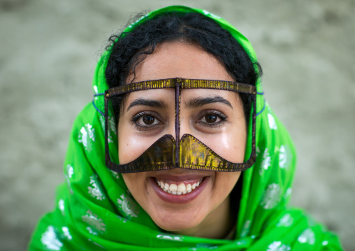 a smiling bandari woman wearing a traditional mask called the burqa with a moustache shape, Qeshm Island, Salakh, Iran