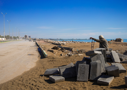 lonely man sit on concrete blocks, Hormozgan, Bandar Abbas, Iran