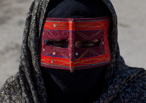 a bandari woman wearing the traditional mask called the burqa on a market, Hormozgan, Bandar Abbas, Iran