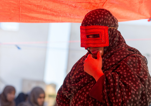 a bandari woman wearing the traditional mask called the burqa on a market, Hormozgan, Bandar Abbas, Iran