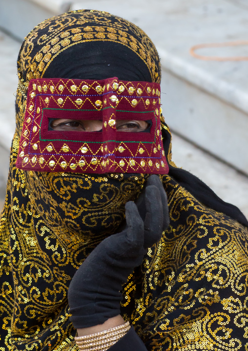 a bandari woman wearing the traditional mask called the burqa on a market, Hormozgan, Bandar Abbas, Iran