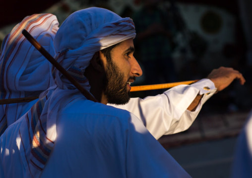 men dressed in white dancing with sticks during a wedding ceremony, Hormozgan, Bandar-e Kong, Iran