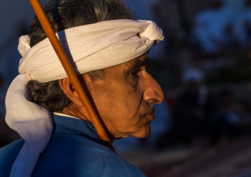 man dressed in white dancing with stick during a wedding ceremony, Hormozgan, Bandar-e Kong, Iran