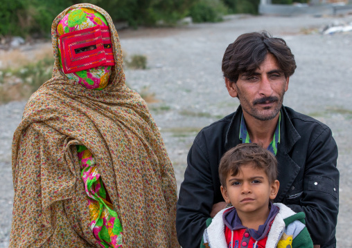 a bandari woman with her husband and son wearing a traditional mask called the burqa at panjshambe bazar thursday market, Hormozgan, Minab, Iran