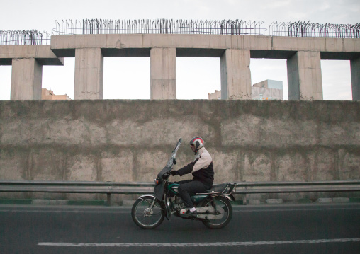 elderly iranian man riding a motorbike on a highway, Central district, Theran, Iran