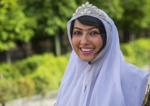 Young woman pausing in narenjestan garden in traditional clothing, Fars province, Shiraz, Iran