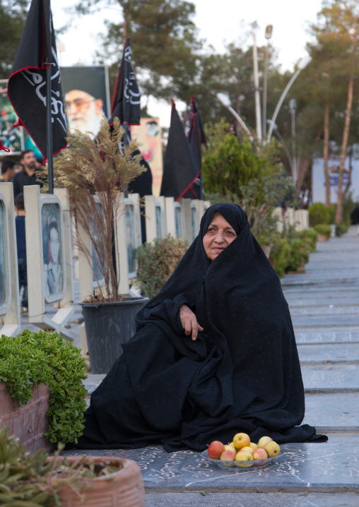 Mother on the tomb of her son killed in the Iran Iraq war in the Rose garden of martyrs cemetery, Isfahan Province, Isfahan, Iran