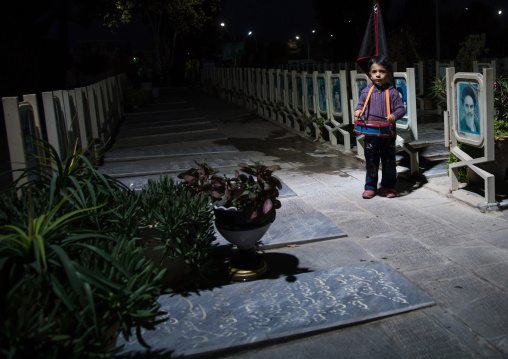 Portrait of an iranian shiite boy playing drum in the Rose garden of martyrs cemetery, Isfahan Province, Isfahan, Iran