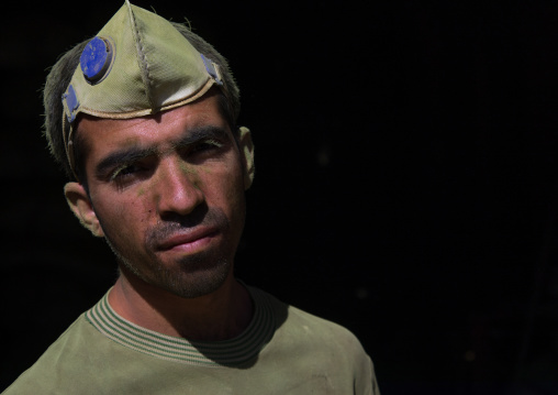 Portrait of an afghan worker with green dust on his face in a traditional henna mill, Yazd Province, Yazd, Iran