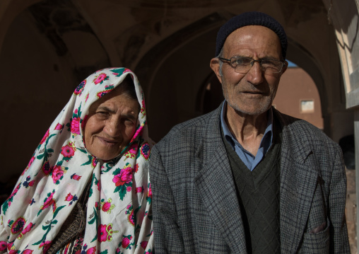 Portrait of an iranian woman wearing traditional floreal chador with her husband in zoroastrian village, Natanz County, Abyaneh, Iran