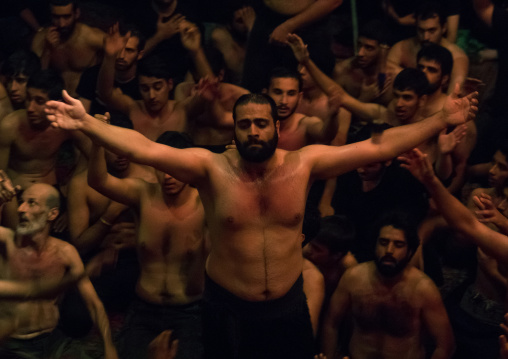 Iranian shiite muslim mourners from the mad of Hussein community chanting and self-flagellating during Muharram in their hosseinieh, Isfahan Province, Kashan, Iran