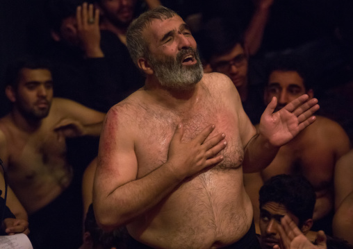 Portrait of iranian shiite muslim mourner from the mad of Hussein community chanting and self-flagellating during Muharram in a Hosseinieh, Isfahan Province, Kashan, Iran