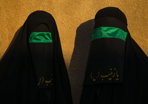 Portrait of iranian shiite muslim women with their faces hidden by a veil mourning Imam Hussein on Tasua during the Chehel Manbar ceremony one day before Ashura, Lorestan Province, Khorramaba