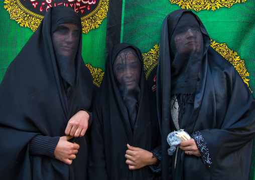 Portrait of iranian shiite muslim women with their faces hidden by a veil mourning Imam Hussein on Tasua during the Chehel Manbar ceremony one day before Ashura, Lorestan Province, Khorramaba