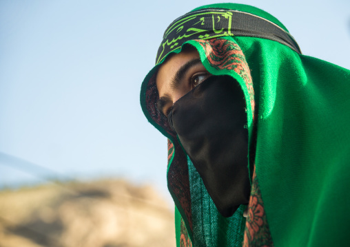 Iranian shiite muslim man with his face hidden by a veil mourning Imam Hussein on Tasua during the Chehel Manbar ceremony one day before Ashura, Lorestan Province, Khorramabad, Iran