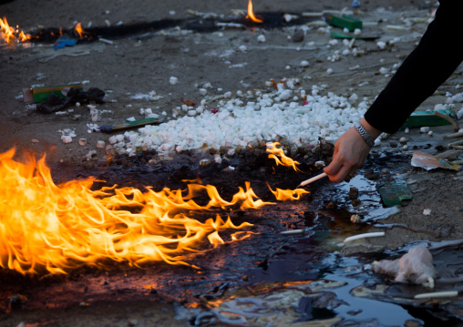 Iranian woman lights candle and puts sugar cubes during Chehel Manbar festival on Tasua to commemorate the martyrdom anniversary of Hussein, Lorestan Province, Khorramabad, Iran