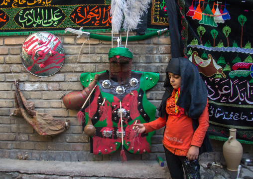 A litle girl stands in front Imam Hussein clothes during the Chehel Manbar ceremony one day before Ashura, Lorestan Province, Khorramabad, Iran