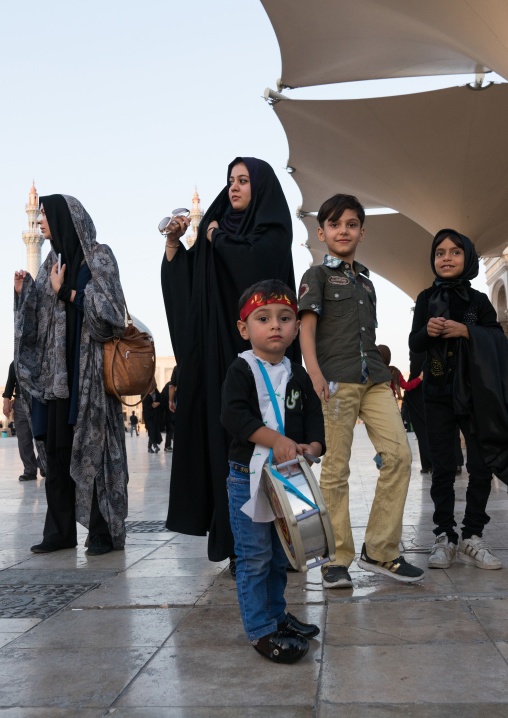 Small boy with a drum in Fatima al-Masumeh shrine esplanade during Muharram, Central County, Qom, Iran