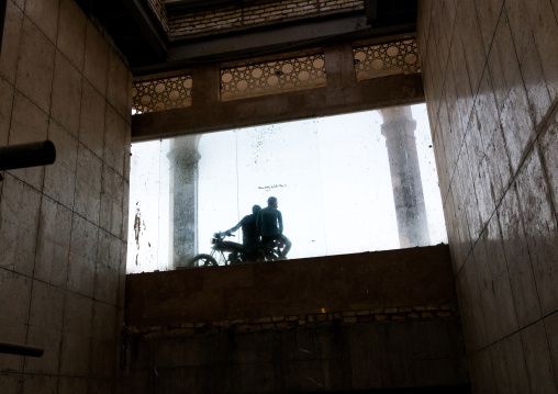 Men sit on a motorbike in front of Imam Hassan mosque, Central County, Qom, Iran