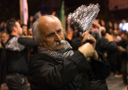 Iranian shiite muslim men beating themselves with iron chains during Muharram, Lorestan Province, Khorramabad, Iran