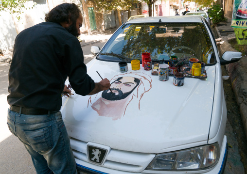 An artist paints the portrait of Abbas Bin Ali on a Peugeot car for Ashura celebrations to commemorate the martyrdom anniversary of Hussein, Lorestan Province, Khorramabad, Iran