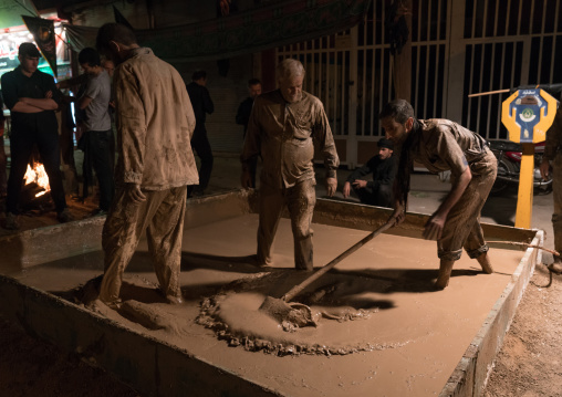 Iranian shiite muslim men prepare a mud pond for the Kharrah Mali ritual during the Ashura ceremony, Lorestan Province, Khorramabad, Iran