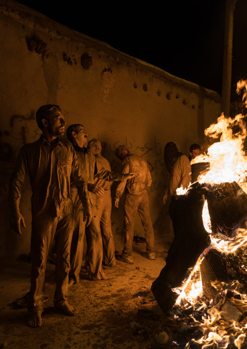 Iranian shiite muslim men gather around a bonfire after rubbing mud on their bodies during the Kharrah Mali ritual to mark the Ashura ceremony, Lorestan Province, Khorramabad, Iran