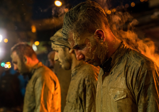 Iranian shiite muslim men gather around a bonfire after rubbing mud on their bodies during the Kharrah Mali ritual to mark the Ashura ceremony, Lorestan Province, Khorramabad, Iran