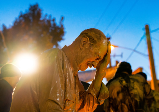 Iranian shiite muslim man crying after rubbing mud on his body during the Kharrah Mali ritual to mark the Ashura ceremony, Lorestan Province, Khorramabad, Iran