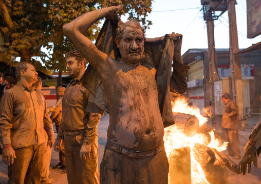 Iranian shiite muslim gather around a bonfire after rubbing mud on their bodies during the Kharrah Mali ritual to mark the Ashura ceremony, Lorestan Province, Khorramabad, Iran