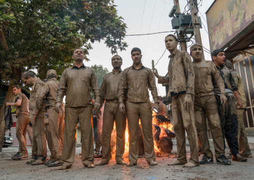 Iranian shiite muslim men gather around a bonfire after rubbing mud on their bodies during the Kharrah Mali ritual to mark the Ashura day, Lorestan Province, Khorramabad, Iran