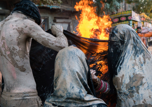 Iranian shiite muslim women gather around a bonfire after rubbing mud on their chadors during the Kharrah Mali ritual to mark the Ashura day, Lorestan Province, Khorramabad, Iran