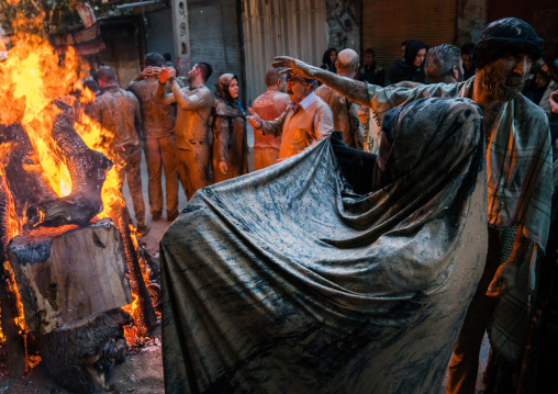 Iranian shiite muslim men and women gather around a bonfire after rubbing mud on their clothes during the Kharrah Mali ritual to mark the Ashura day, Lorestan Province, Khorramabad, Iran