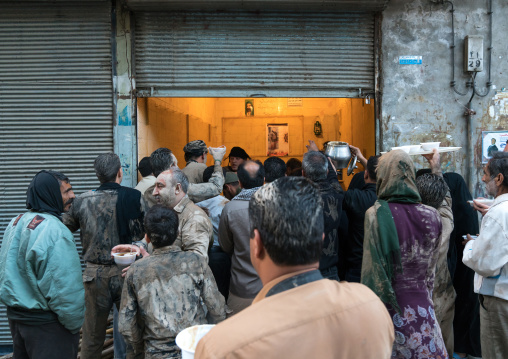 Iranian shiite muslim people collect their breakfasts after rubbing mud on their bodies early in the morning of Ashura day, Lorestan Province, Khorramabad, Iran