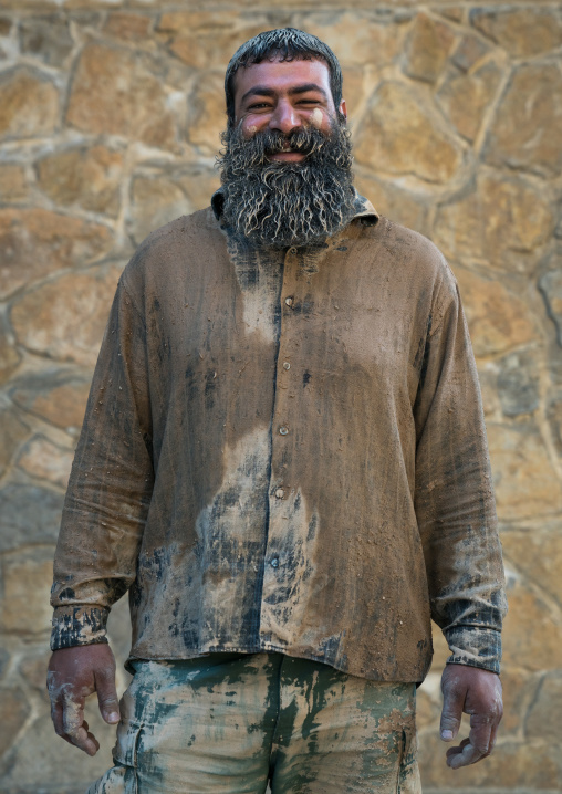 Iranian shiite muslim man after rubbing mud on his clothes during the Kharrah Mali ritual to mark the Ashura ceremony, Lorestan Province, Khorramabad, Iran