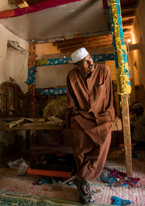 man sitting on the bed of a wedding room, Qeshm Island, Tabi, Iran