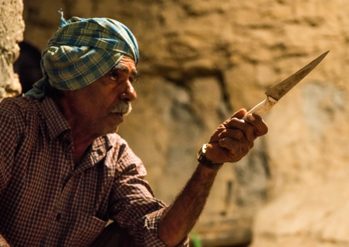 butcher preparing the knives before the slaughter of a cow for a wedding, Qeshm Island, Tabl , Iran