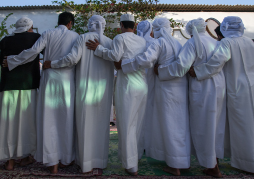 men dressed in white dancing during a wedding ceremony, Hormozgan, Bandar-e Kong, Iran