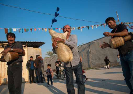 men dancing and playing sheep skin pipe bag during a wedding ceremony, Hormozgan, Kushkenar, Iran