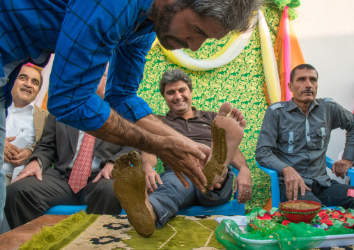 groom being covered with henna during his wedding ceremony, Hormozgan, Kushkenar, Iran