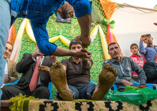 groom hands and feet being covered with henna during his wedding ceremony, Hormozgan, Kushkenar, Iran