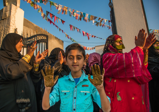 young boy being covered with henna during a wedding ceremony, Hormozgan, Kushkenar, Iran