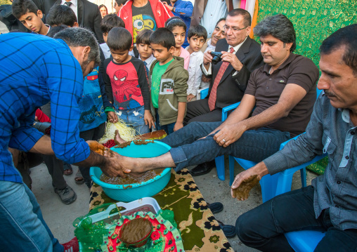 groom feet being covered with henna during his wedding ceremony, Hormozgan, Kushkenar, Iran